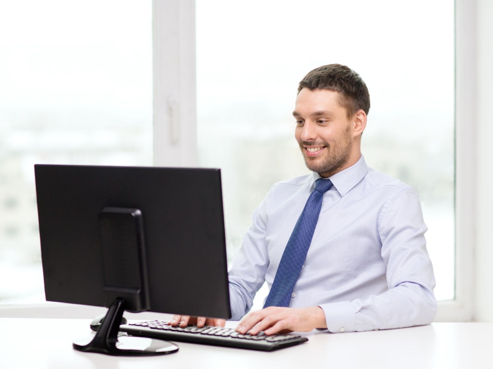 Male doctor typing on computer.